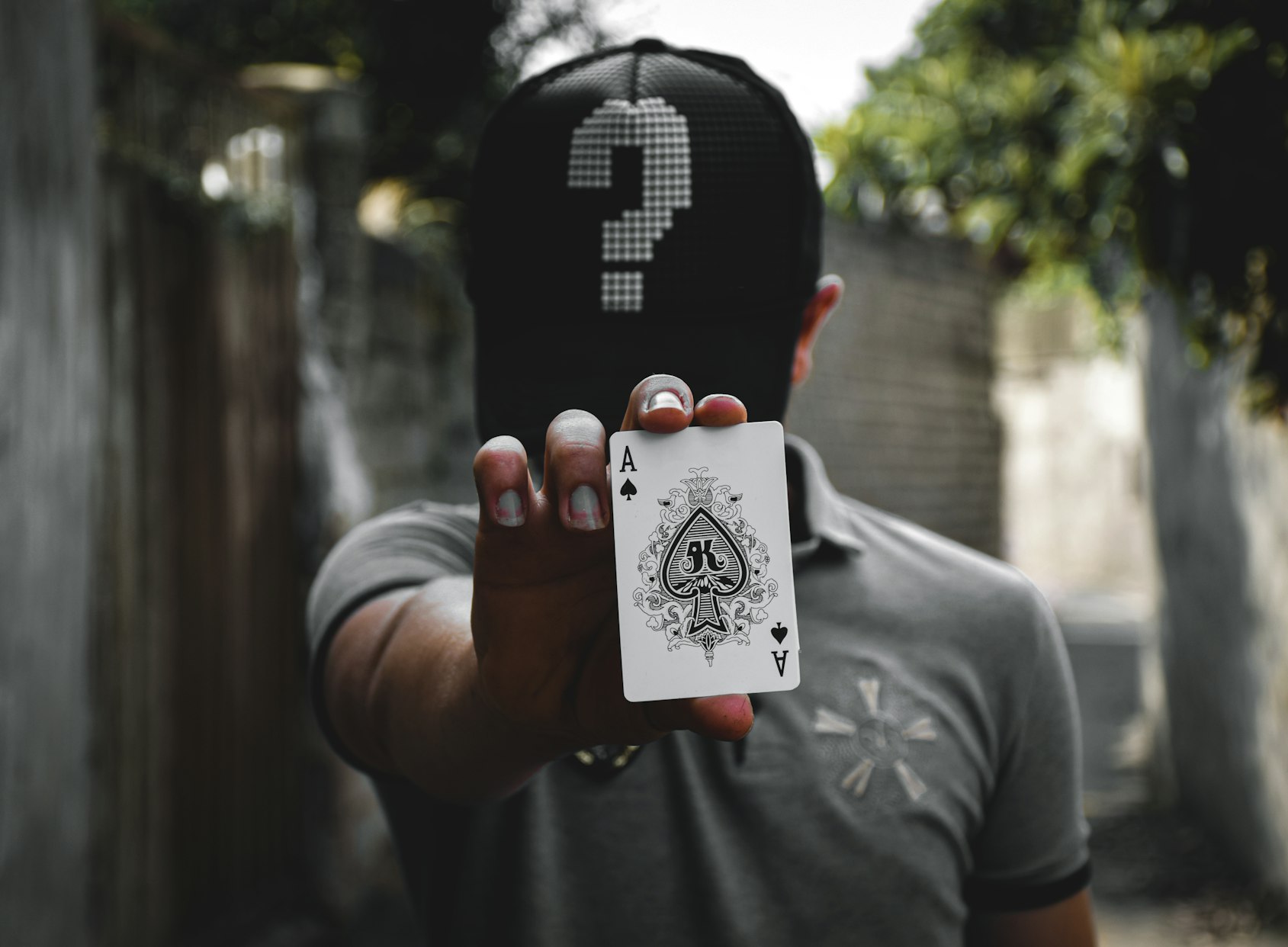 man with head down holding an ace card